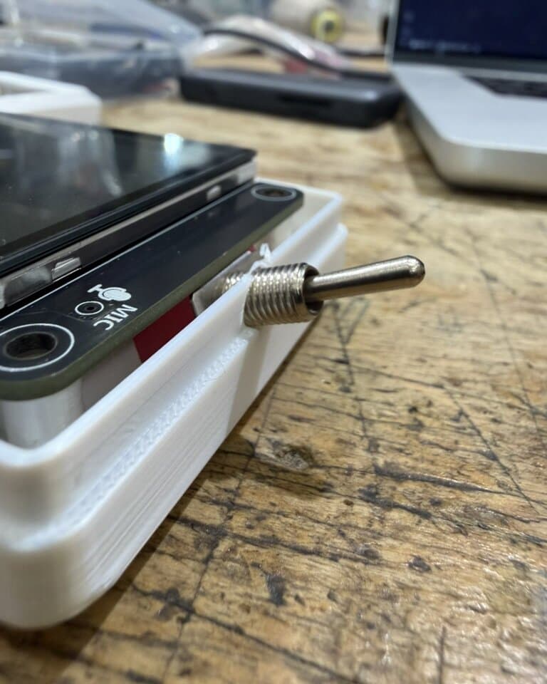 Close-up of a toggle switch through a printed enclosure wall, print layer lines clearly visible